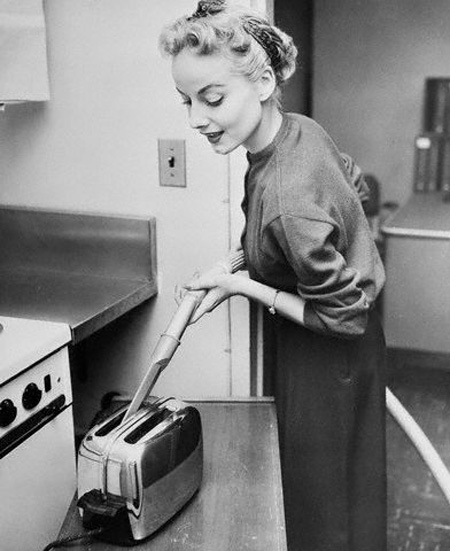 Woman Cleaning Toaster with Vacuum Cleaner